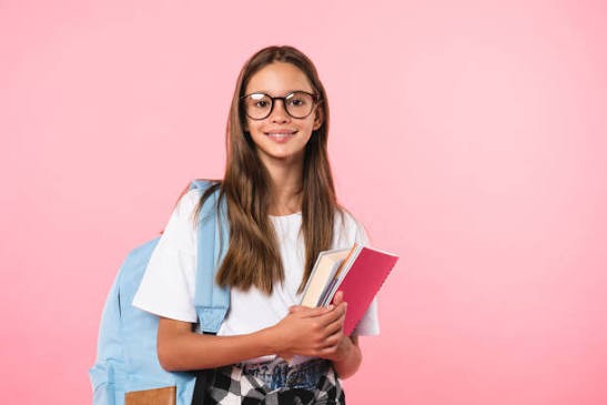 Collégienne à lunettes, cahiers dans les bras et sac à dos